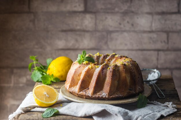 Homemade lemon bundt cake with icing sugar on a black background