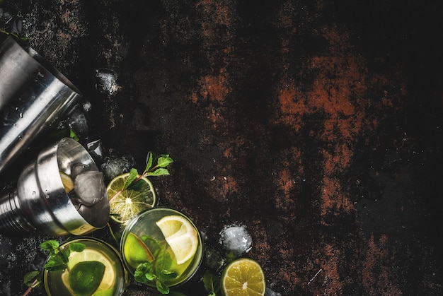 Photo homemade lemonade or mojito cocktail with fresh lime and mint leaves, dark rusty metal ,  top view