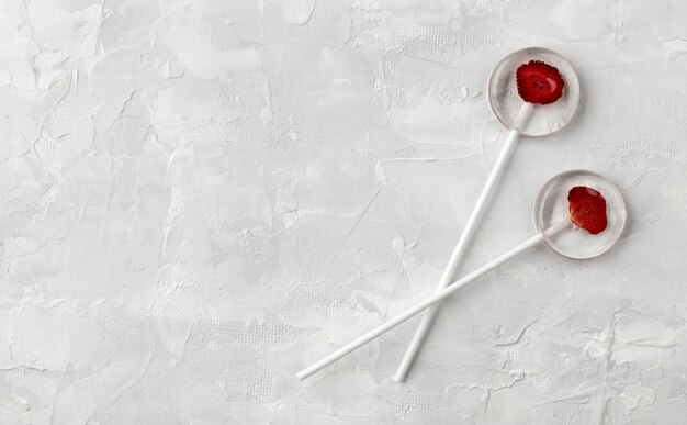 Homemade lollipops made from natural dehydrated berries on gray background