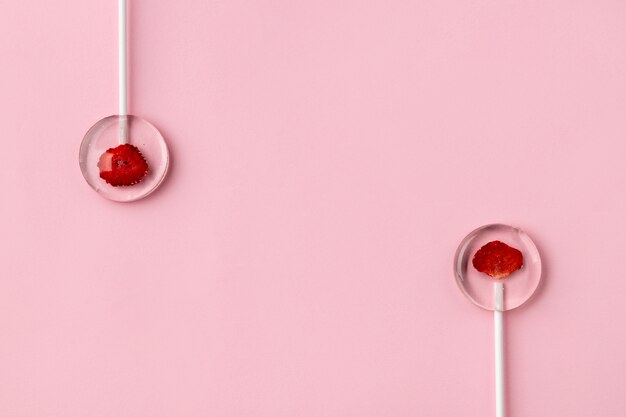 Homemade lollipops made from natural dehydrated berries on pink background