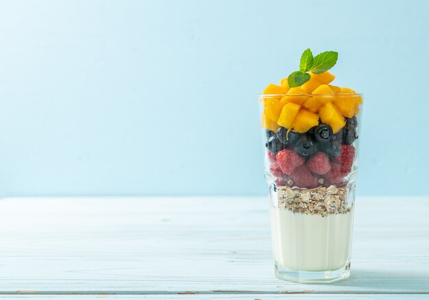 homemade mango, raspberry and blueberry with yogurt and granola - healthy food style