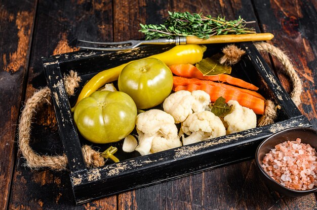 Homemade marinated and pickles vegetables preserve on a wooden tray