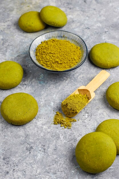 Homemade matcha green tea cookies with matcha powder on grey concrete