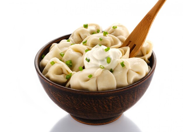 Homemade meat dumplings - russian pelmeni. Dumplings, filled with meat on white. Isolated on white