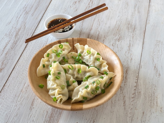 Homemade Meat Dumplings on wooden plate, top view.