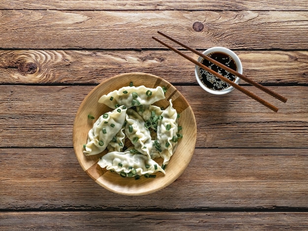 Homemade Meat Dumplings on wooden plate, top view.