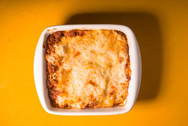 Homemade Meat lasagna on wooden yellow table top view