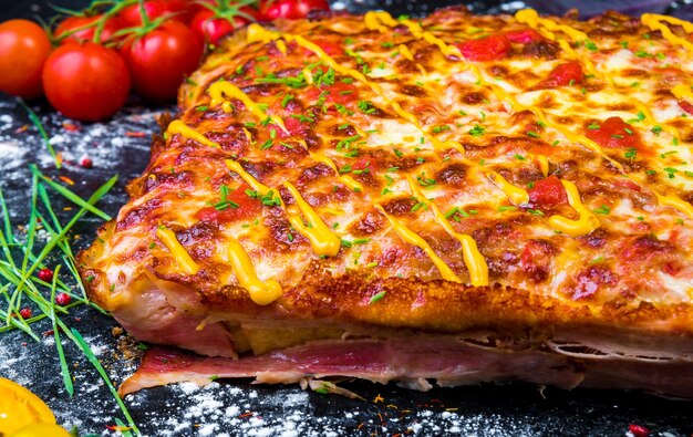 Torta di pizza di carne fatta in casa con il primo piano a fette di pancetta sul tavolo. vista orizzontale dall'alto.