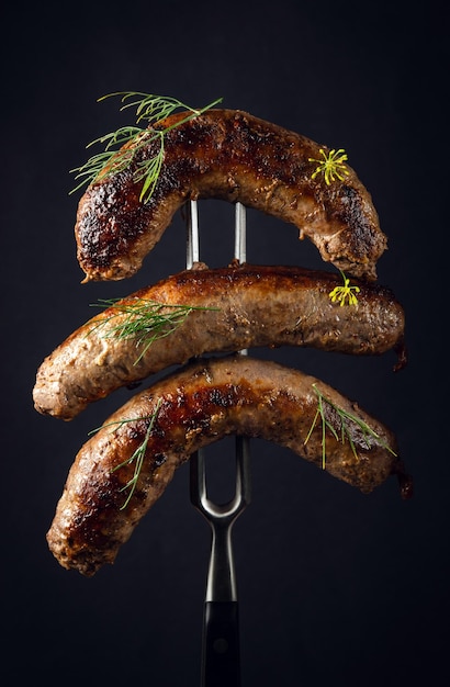 Homemade meat sausages sprinkled with dill on a fork Delicious lunch or dinner idea