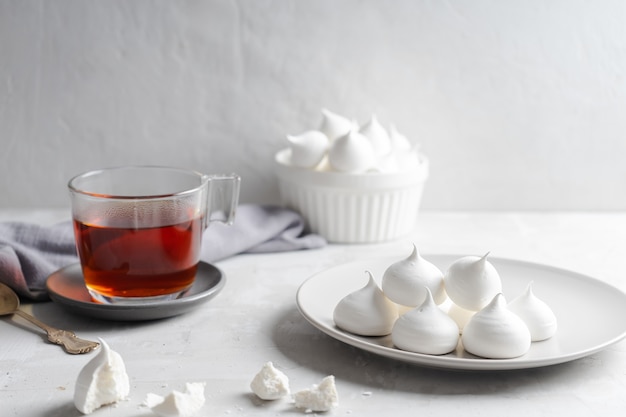 Homemade meringue and cup of tea on gray background