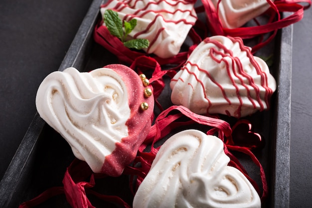 Homemade meringues in heart shape in old wooden box for Valentine's day