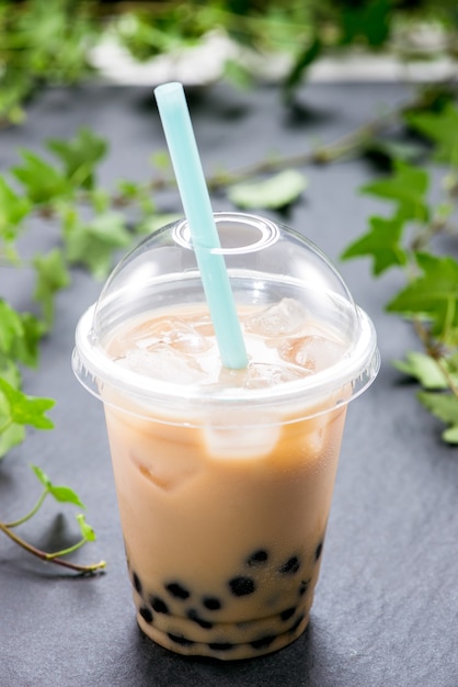 Homemade milk bubble tea in plastic cups on table.