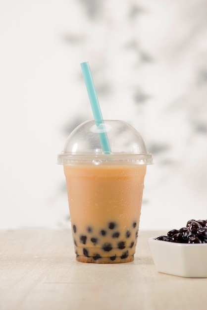 Homemade milk bubble tea in plastic cups on table.