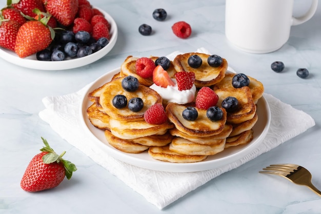 Homemade mini pancakes with blueberries strawberries and raspberries