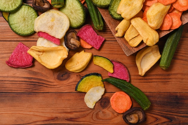 Homemade mix vegetable chips on wooden background.