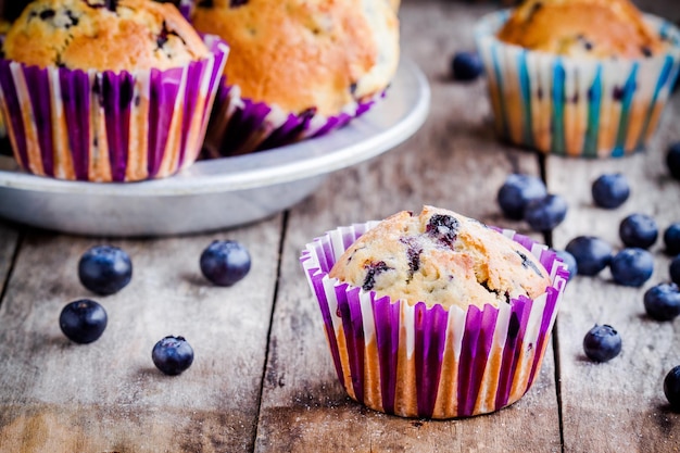 Homemade muffins with blueberries closeup on a rustic wooden background