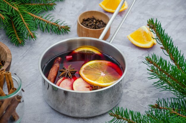 Homemade mulled wine in a saucepan on a gray table