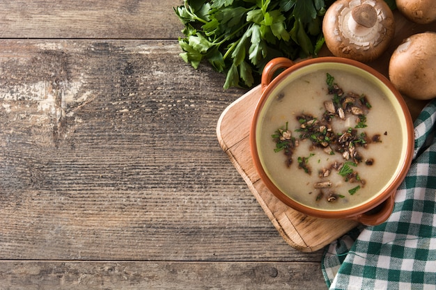 Homemade mushroom soup in bowl on wood table Top view 