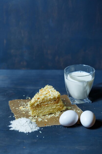 Homemade Napoleon cake with cream on a gray background