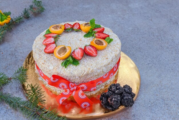 Homemade Napoleon layer cake with strawberry and apricot on a rustic wooden background