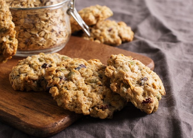 Homemade oat cookies on dark grey or brown background, healthy snack, copy space