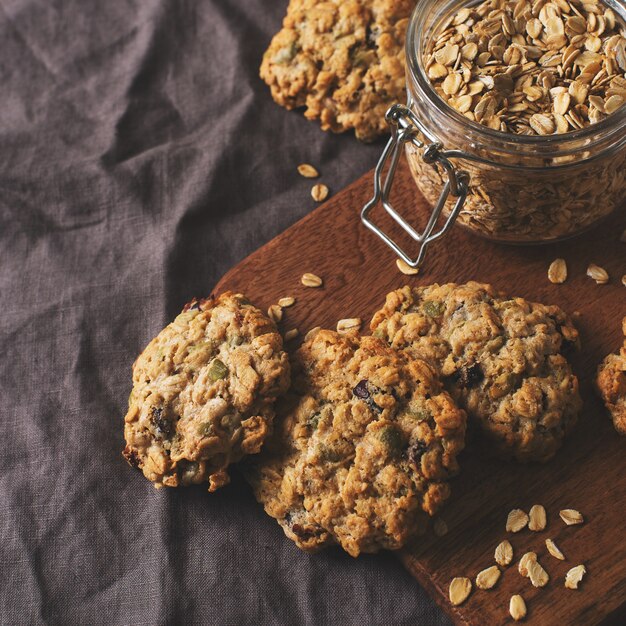 Homemade oat cookies on dark grey or brown background, healthy snack, copy space