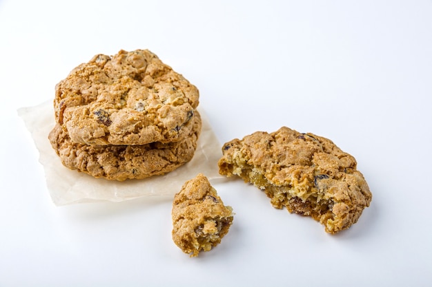 Homemade oatmeal cookies with raisins and chocolate on white background