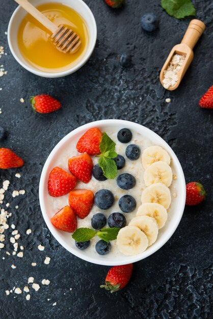 Porridge di farina d'avena fatto in casa con latte, miele e frutti di bosco freschi