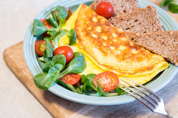 Homemade omelette with salad on plate. Healthy food concept