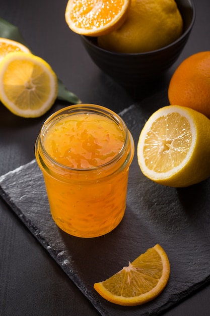 黒い石のテーブルの上の瓶に自家製オレンジジャム