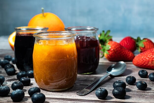 Homemade orange marmalade assortment of homemade jams in glass jars Front view seasonal fruit jam