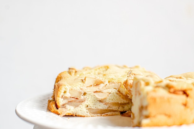 Photo homemade organic apple pie dessert charlotte. cobbler apple pie on white plate and white background