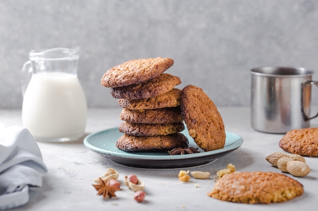 Homemade organic oatmeal cookies with peanuts and jar of milk