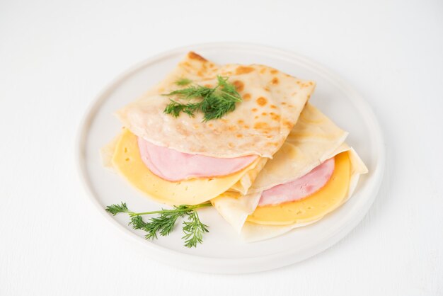 Homemade pancakes with ham and cheese on a white surface, Maslenitsa, top view