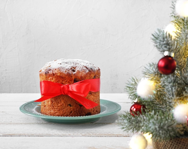 Homemade panettone on light background with christmas tree tradidional italian copy space