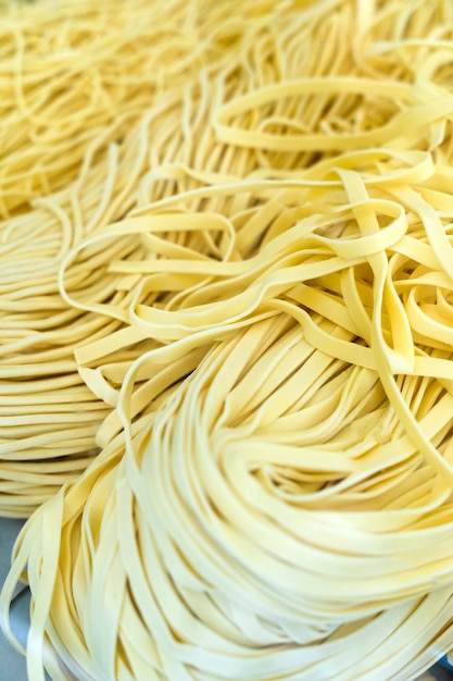 Homemade pasta Fresh raw italian fettuccine pasta on a wooden kitchen table