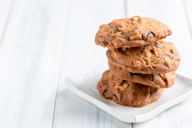 Homemade pastry cookies on white dish on white wood background