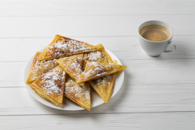 Homemade patties on a plate and a cup of coffee