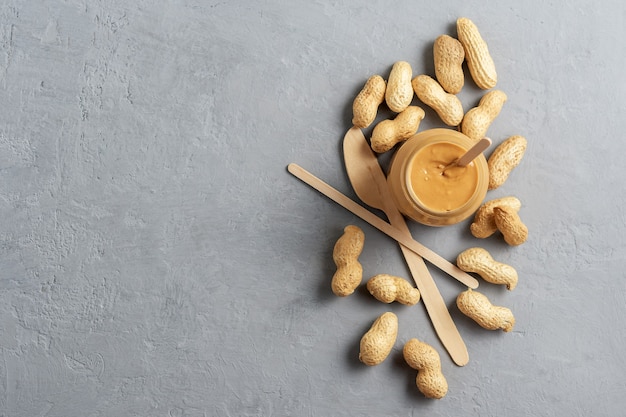 Homemade peanut butter in glass jars on the concrete surface