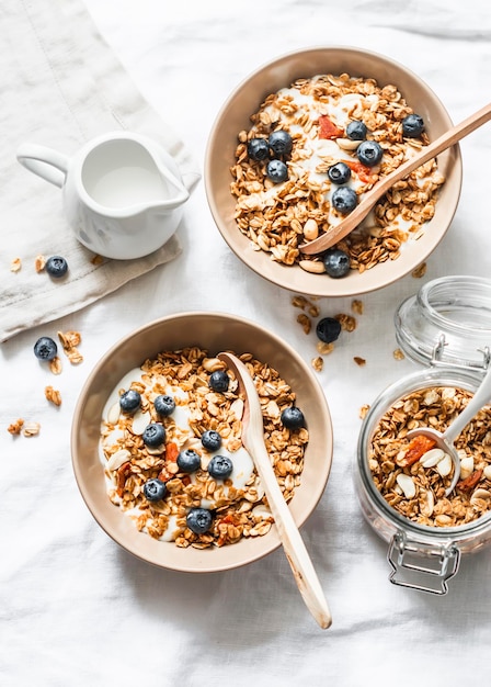 Homemade peanut butter granola with greek yogurt and blueberries on a light background top view
