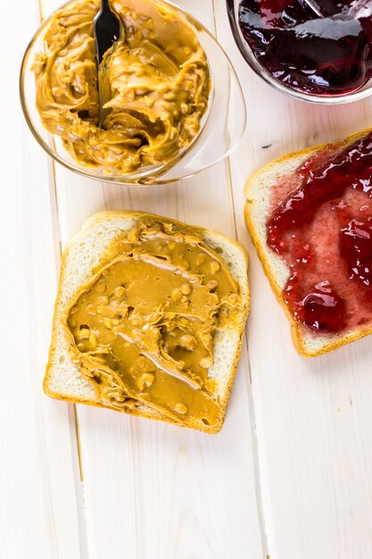 Photo homemade peanut butter and jelly sandwich on white bread.