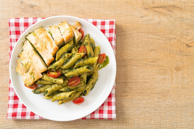 Homemade penne pasta in pesto sauce with grilled chicken