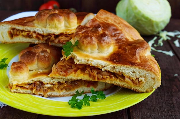 Homemade pie with cabbage chopped pieces on a dark wooden background. Close up