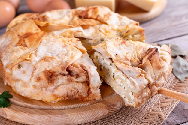 Homemade pie with cheese and herbs on the table