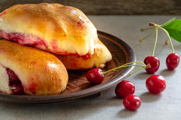 Homemade pies with cherries in a clay plate Homemade baking