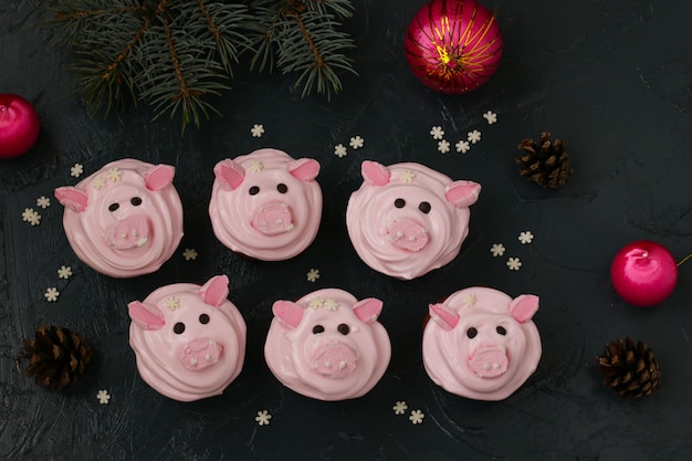 Homemade Pink cupcakes decorated with protein cream and marshmallow shaped funny piggies