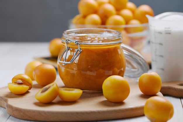 Homemade pitted yellow plum jam in a glass jar