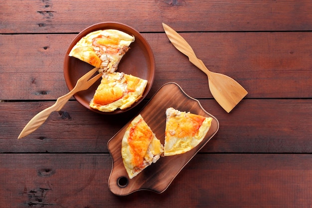 점토 접시와 커팅 보드에 집에서 만든 피자 피자와 갈색 배경 복사 공간에 나무 칼 붙이