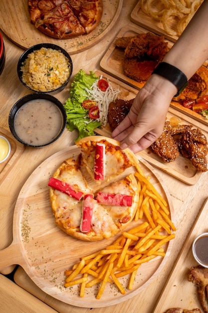 Homemade pizza and fries on a wooden table