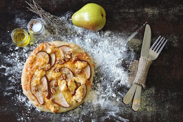 Homemade pizza with pear, cheeses and walnuts.